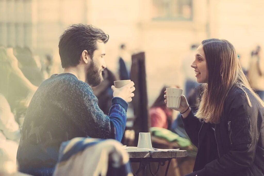 man and woman drinking coffee outside